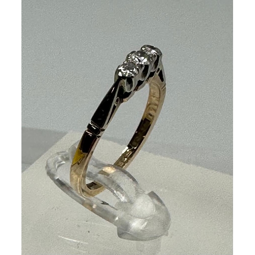 600 - A 9ct gold and platinum three stone diamond ring, size L.