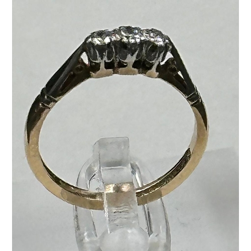 600 - A 9ct gold and platinum three stone diamond ring, size L.