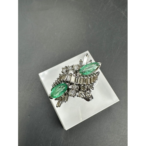 602 - An emerald and diamond ring, designed a s a vertically set elongated cluster with two marquise cut e... 