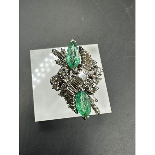 602 - An emerald and diamond ring, designed a s a vertically set elongated cluster with two marquise cut e... 