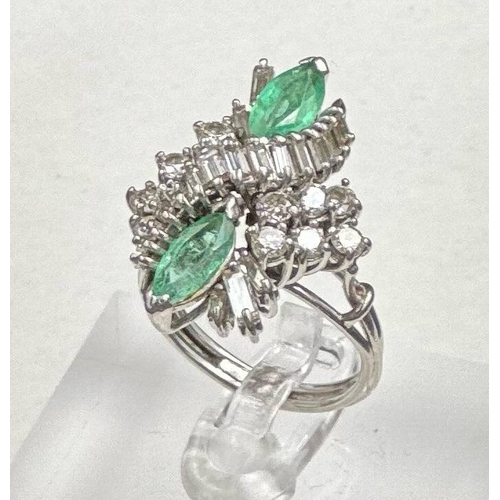 602 - An emerald and diamond ring, designed a s a vertically set elongated cluster with two marquise cut e... 