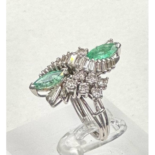 602 - An emerald and diamond ring, designed a s a vertically set elongated cluster with two marquise cut e... 