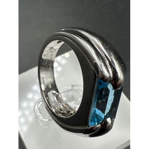 603 - A single stone Audemars Piguet ring consisting of a rectangular mixed cut blue topaz stone (12.1mm x... 