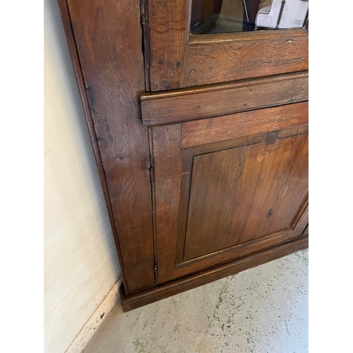 72 - An oak corner cupboard with glazed door and panelled cupboard (H210cm W95cm D64cm)