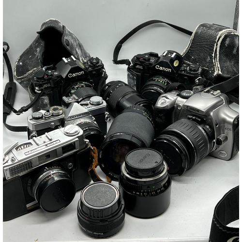 721 - Five cameras and lenses, various aged and makers including Olympus, Cannon etc