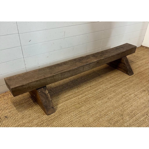 75 - A reclaimed oak bench on triangular feet (H30cm W180cm)