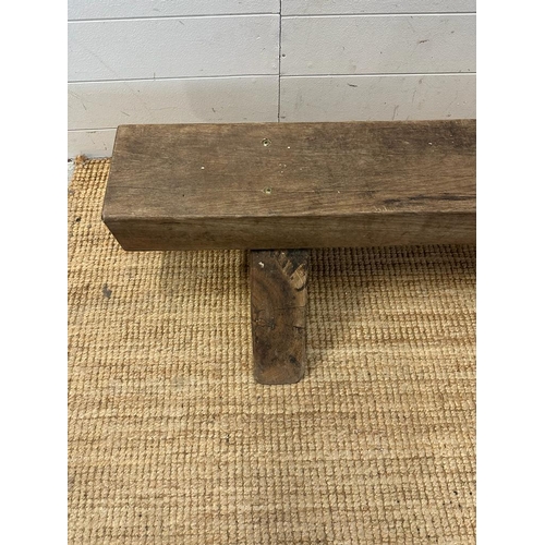 75 - A reclaimed oak bench on triangular feet (H30cm W180cm)