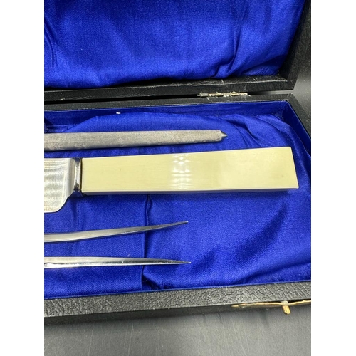 760 - A boxed stainless steel carving set from Harrods of London to include knife, fork and steel