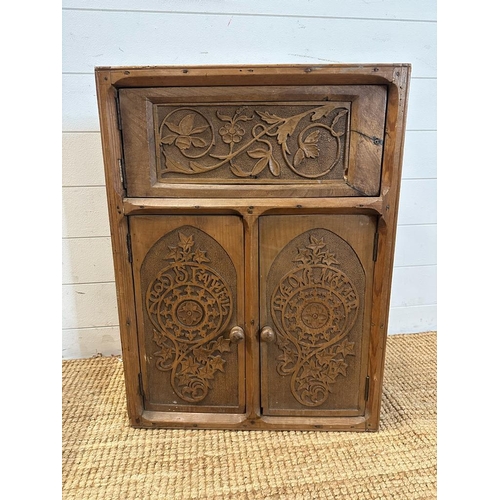 77 - A pine three door corner cupboard carved to front (H68cm W51cm D30cm)