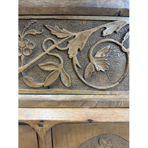 77 - A pine three door corner cupboard carved to front (H68cm W51cm D30cm)