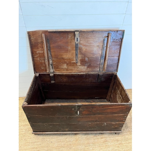 86 - A large wooden chest with wrought iron lock on wooden feet (H70cm W121cm D60cm)