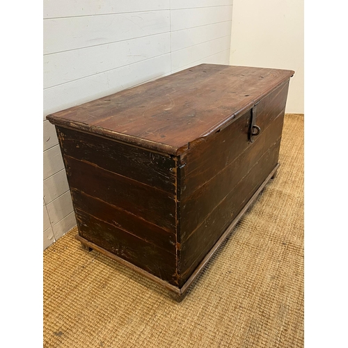 86 - A large wooden chest with wrought iron lock on wooden feet (H70cm W121cm D60cm)