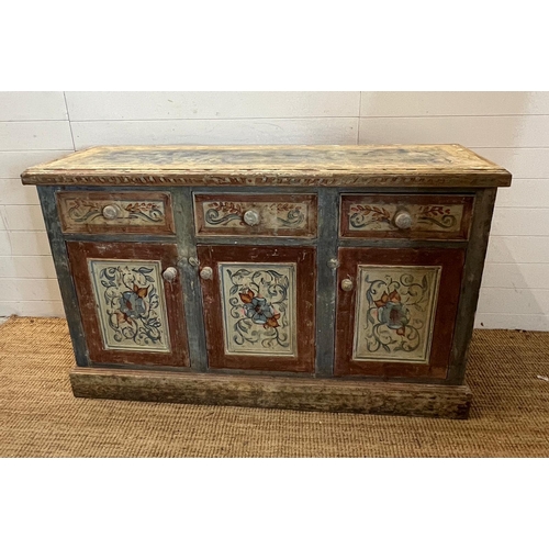 90 - A vintage pine sideboard comprising of three drawers and three cupboards under with painted floral d... 