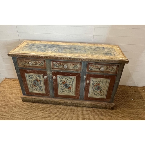 90 - A vintage pine sideboard comprising of three drawers and three cupboards under with painted floral d... 