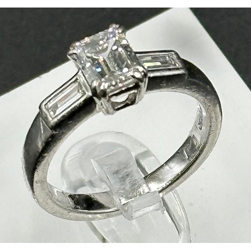 555A - Diamond ring with centrally set emerald cut diamond, approx 6.48mm x 5.03mm x 3.34mm, stated weight ... 