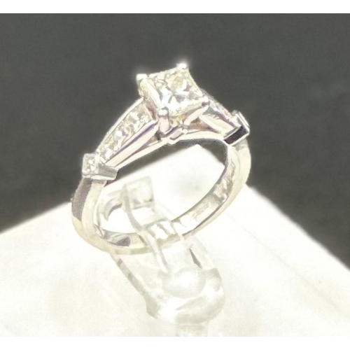 555C - A diamond single stone ring with diamond set shoulders and mount. Princess cut diamond, measuring 5.... 