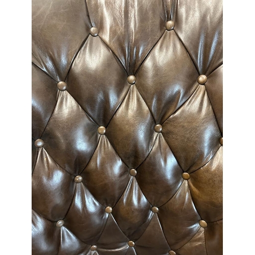 101 - A brown leather button backed wing arm chair by Henredon leather company with brass studs and castor... 