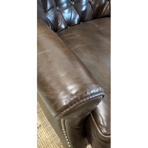 101 - A brown leather button backed wing arm chair by Henredon leather company with brass studs and castor... 