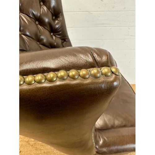 101 - A brown leather button backed wing arm chair by Henredon leather company with brass studs and castor... 