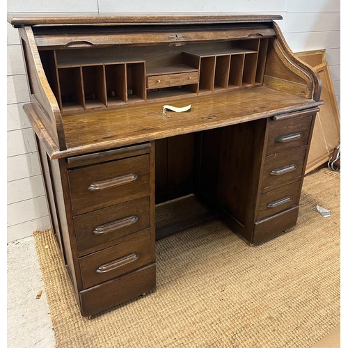 105 - An Edwardian oak roll top desk comprising of six drawers, storage compartments and original key (H11... 