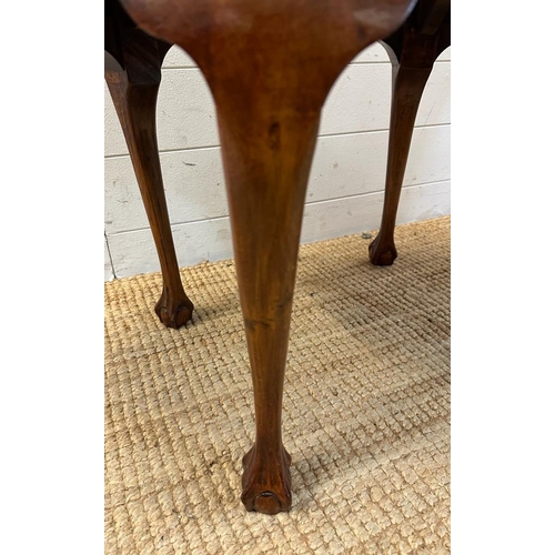 125 - An oval mahogany side table on claw and ball feet (H46cm W75cm D51cm)