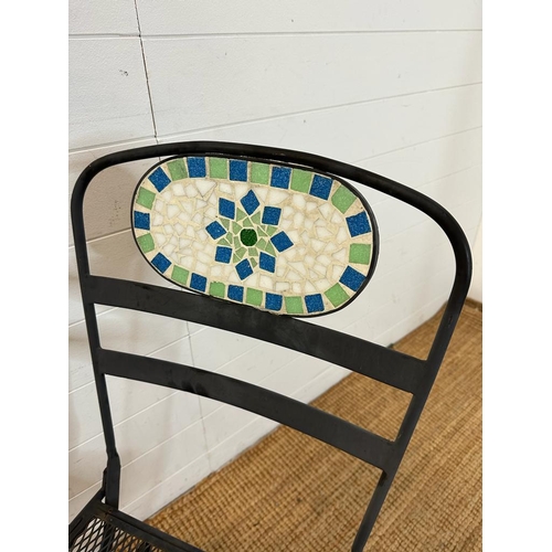 138 - Two black wrought iron garden chairs with tiled mosaic backs and a bistro table frame