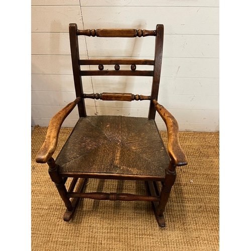 14 - An oak and rustic style rush seat rocking chair