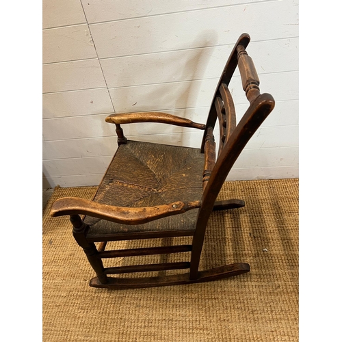 14 - An oak and rustic style rush seat rocking chair