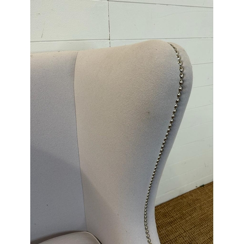 145 - A contemporary wing back arm chair, upholstered in lilac