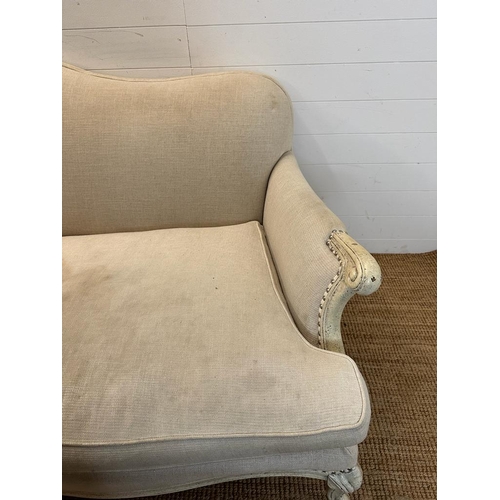 146 - A four seater Louis style sofa with white painted frame and studded beige upholstery (224cm x 112cm)