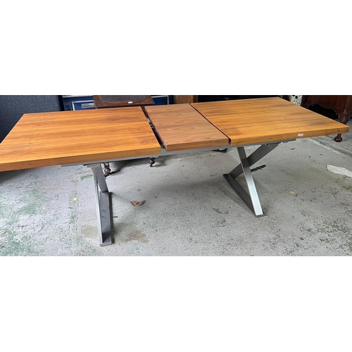 154 - An expanding dining table with brushed steel X frame legs