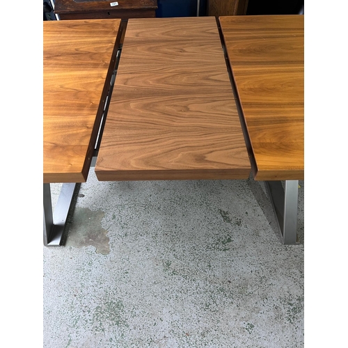 154 - An expanding dining table with brushed steel X frame legs