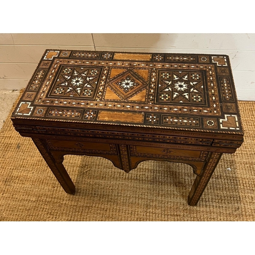 16 - A marquetry inlaid games table with playing surface, back gammon, chess board etc , Damasais or Syri... 