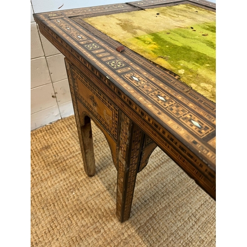 16 - A marquetry inlaid games table with playing surface, back gammon, chess board etc , Damasais or Syri... 