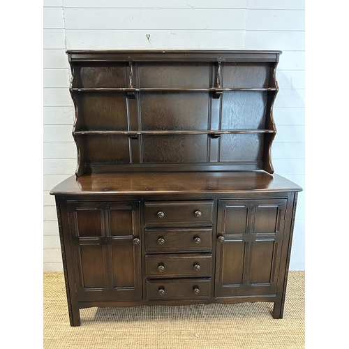 181 - A dark Ercol dresser comprising of four drawer flanked by cupboards and a two tier plate rack over (... 