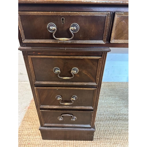 187 - A pedestal desk with brown leather top, a central long drawer flanked on either side by four short d... 