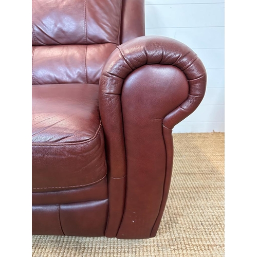 189 - A red leather three piece suite comprising of two arm chairs and a two seater sofa