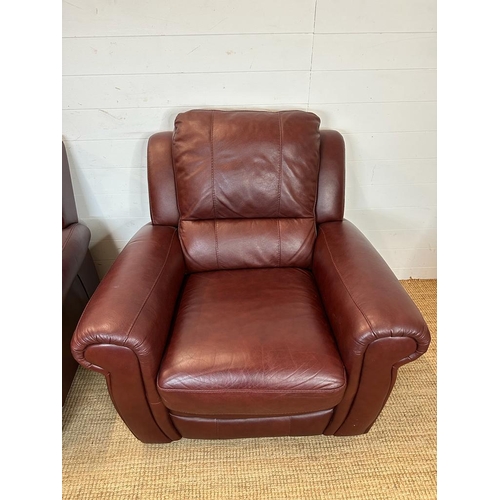 189 - A red leather three piece suite comprising of two arm chairs and a two seater sofa