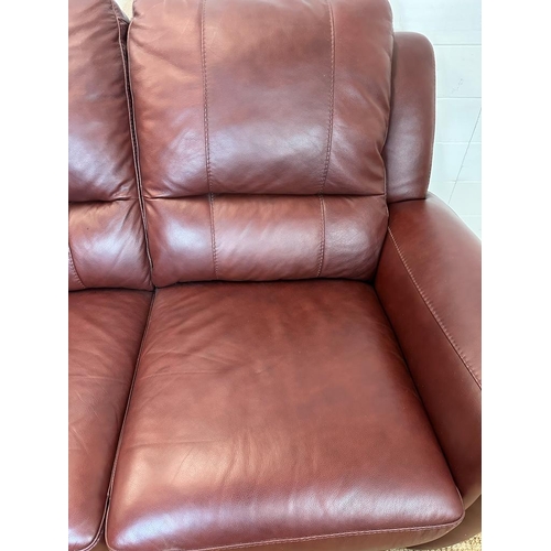 189 - A red leather three piece suite comprising of two arm chairs and a two seater sofa