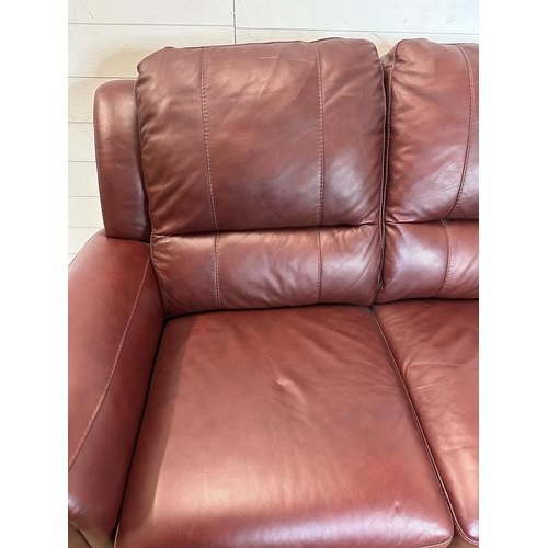 189 - A red leather three piece suite comprising of two arm chairs and a two seater sofa