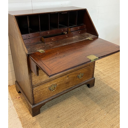 21 - An oak bureau opening to writing slope and bracket feet (H104cm W92cm D56cm)