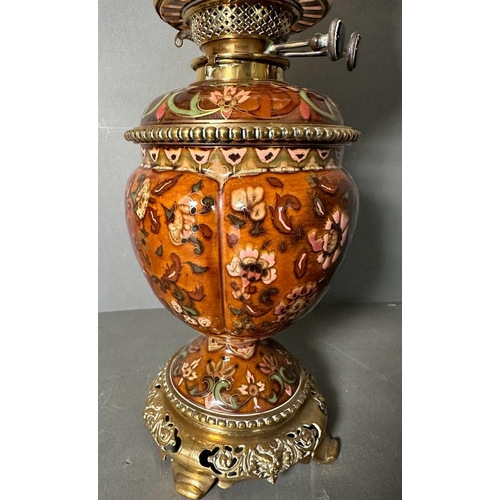 217 - A Victorian oil lamp by Williams And Bach of London. The central floraly painted bowl sitting on bra... 