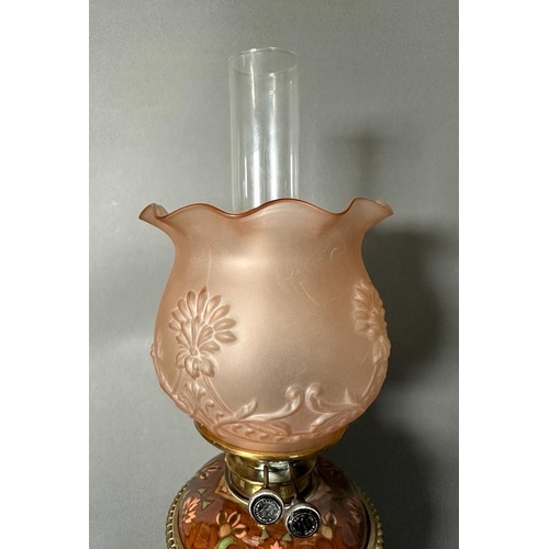 217 - A Victorian oil lamp by Williams And Bach of London. The central floraly painted bowl sitting on bra... 