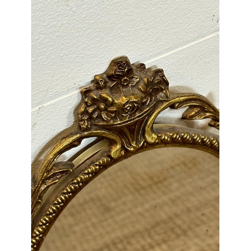 261 - A metal gold painted mirror in the Rococo style 50cm x 27cm