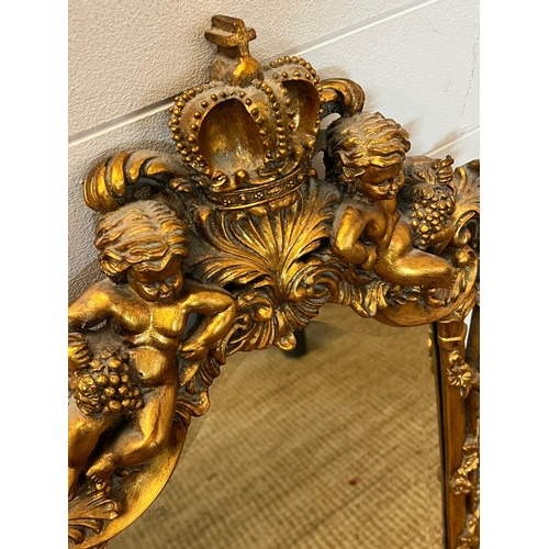 272 - A gilt framed mirror with heavy carved cherubs 78cm x 48cm