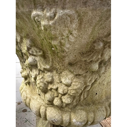 290 - A weathered concrete garden urn with a grape vine design on a square base (H65cm Dia60m)