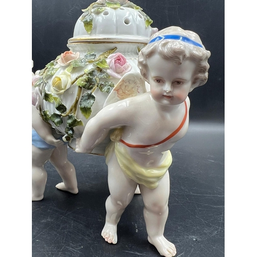 378 - A Sitzendorf porcelain center piece with three cherubs supporting a lidded bowl decorated with flowe... 