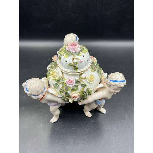 378 - A Sitzendorf porcelain center piece with three cherubs supporting a lidded bowl decorated with flowe... 