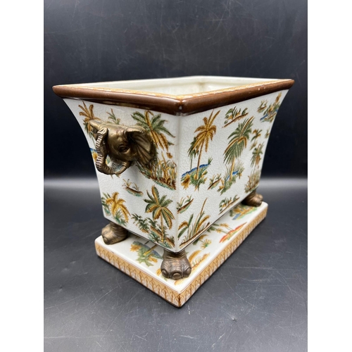 384 - Elephant themed porcelain jardinière with elephant metal handles and legs along with an Elephant the... 