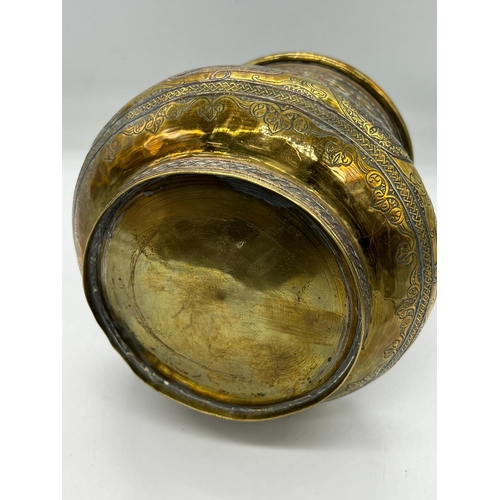 393 - An Islamic vase, the brass vessel is inlaid with copper and Arabic calligraphy (H17cm Dia15cm)